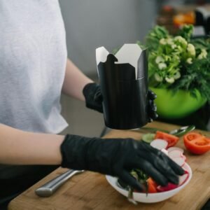 Person preparing a fresh salad meal with vegetables in a modern kitchen setting.
